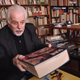 Alejandro Jodorowsky holding a copy of his Dune movie book.